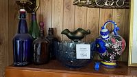 Group showing cobalt bottle, amber jug, green bottle, blue bowl, Spanish vase, miniature creamer