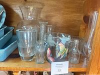 Shelf view showing multiple clear glass vases and hand-painted butterfly glass