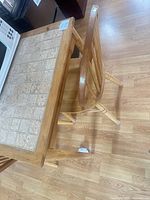 Top view of rectangular wood dining table with tile insets and accompanying wooden chair