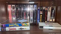 Front view of shelf showing majority of VHS spines and two clamshells