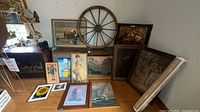 Group shot of wagon wheel and framed artworks against wall