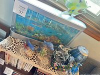 Overall view showing moving aquarium display, glass fish, multiple dolphin figurines and humidifier