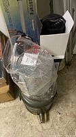 Metal canister, hip waders in plastic, telescope box visible