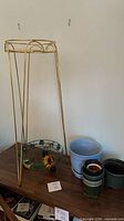 Gold metal stand, stained-glass bowl, blue and green planters visible