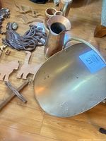 Overview showing metal coal scuttle, copper pitcher, wooden plaques and figures