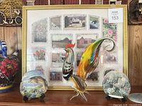 Shelf with framed collage, glass rooster, two decorative plates