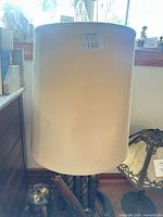 Full view of lamp with shade showing texture and tag
