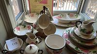 Overview of entire dinnerware set on windowsill showing plates, bowls, platters, and serving pieces