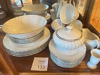 Stacked plates, serving bowls, and part of the covered sugar bowl with silver rim