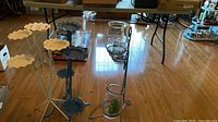 Overall view of three metal stands with glass hurricanes