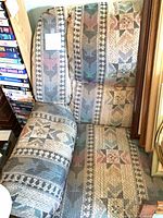 Front angled view of recliner showing fabric pattern, armrest, headrest and overall condition