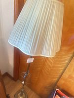Full view of brass floor lamp with pleated shade