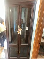 Front view of closed cabinet showing overall design, glass doors, hardware