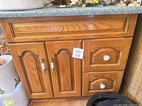 Front view showing two doors and two drawers with knobs and handles