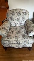 Front view of floral upholstered armchair with cushions