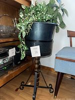 full view of plant stand, pot, sleeve and artificial plant
