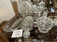 Entire grouping of clear pressed glass pieces on shelf