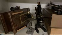 Microscope with wooden case, slide holder and boxes on shelf