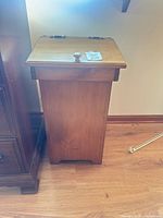 Front view of wood drop-front cabinet standing on floor