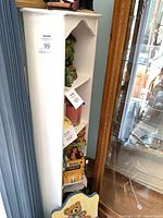 Full view of white corner shelf with four tiers