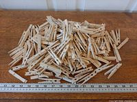 Pile of wooden clothespins with ruler for scale