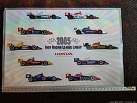 Full poster with ruler showing 24 inch height, graphics of race cars and Honda branding
