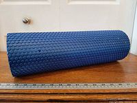Side view of blue dotted EVA foam roller with ruler showing length