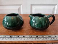 Front view of creamer and sugar bowl with ruler for scale