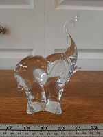 front view of clear crystal elephant figurine on ruler for scale