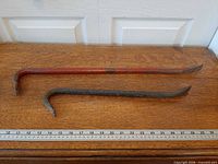 Both crowbars laid parallel with ruler for scale