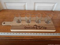 Top view of wooden flight board with four glasses seated in recesses