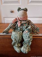 Front view of plush frog doll sitting upright