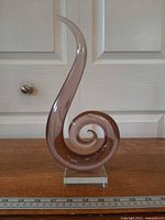 Full front view of purple spiral glass sculpture on base