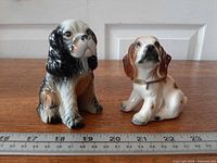 Both porcelain Cocker Spaniel figurines beside ruler