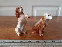Both porcelain spaniel figurines with ruler for scale