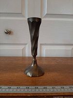 Front view of brass candlestick holder showing twisted stem and base