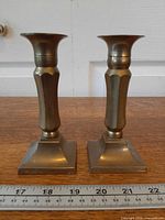 Front view of both brass candlesticks side by side