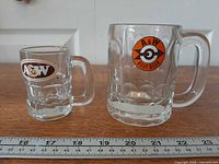Both A&W glass mugs side by side with ruler for scale