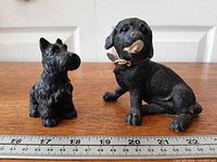 Both figurines beside ruler showing scale