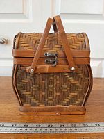 Front view showing wicker pattern, bamboo handles, metal clasp