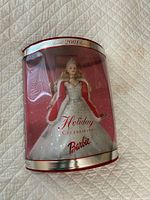 Front view of unopened Holiday Celebration Barbie in clear cylindrical box