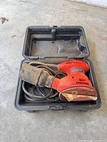 Sander with cord, dust bag and case interior