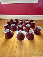 group of 15 burgundy bell chandelier shades upright on floor