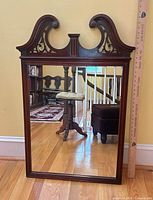 Full view of Chippendale mahogany wall mirror leaning against wall with ruler for scale