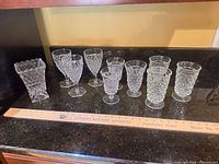 All eleven pressed glass pieces arranged on countertop
