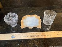 Three glass pieces with ruler for scale