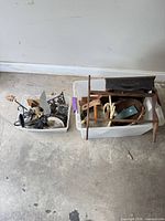 Both plastic bins showing variety of metal, wood and wicker décor items