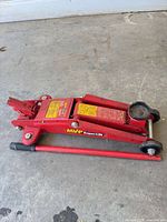 Side view of red MVP SuperLift hydraulic floor jack with handle attached