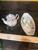 Teapot, tray and saucers grouped together