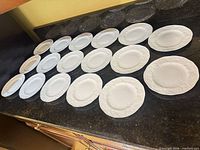 All 17 plates laid out front side showing embossed rims